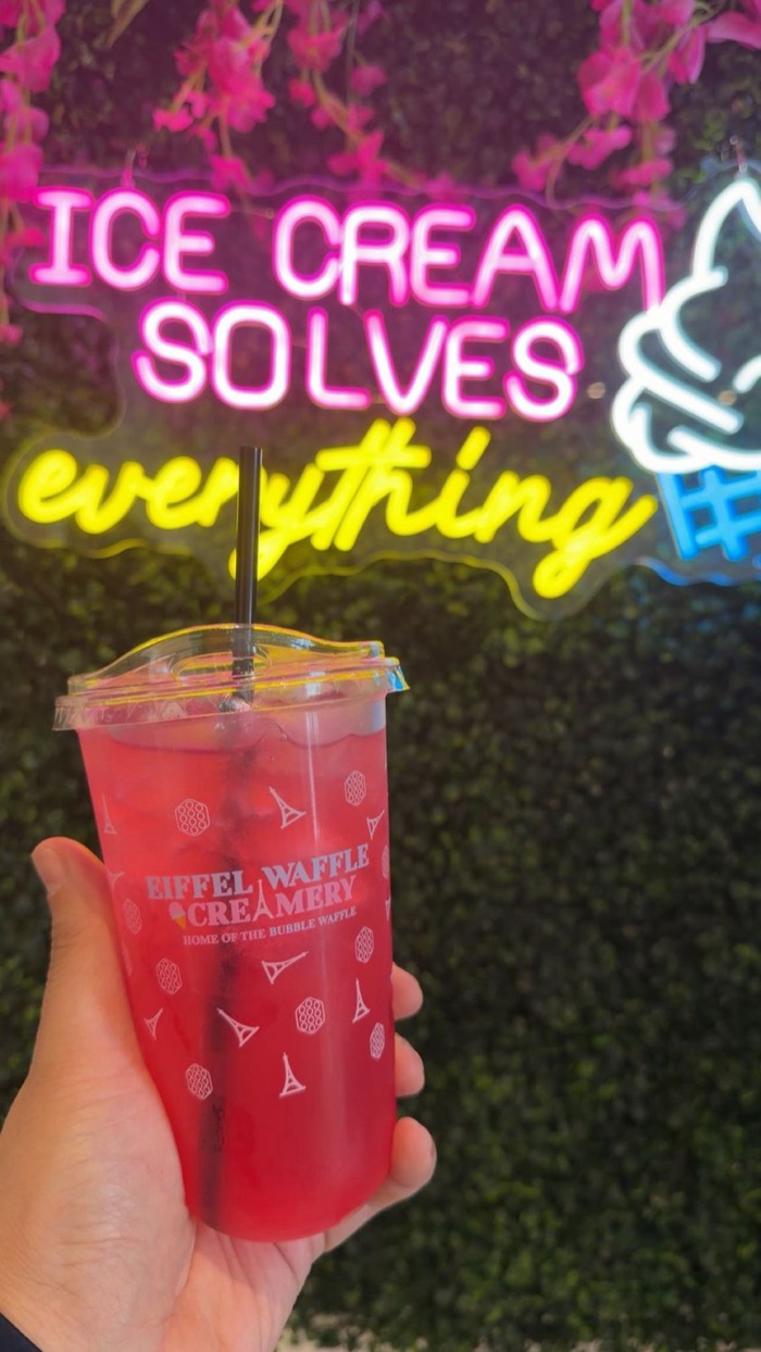 Eiffel Waffle Refresher in a branded cup under the neon sign